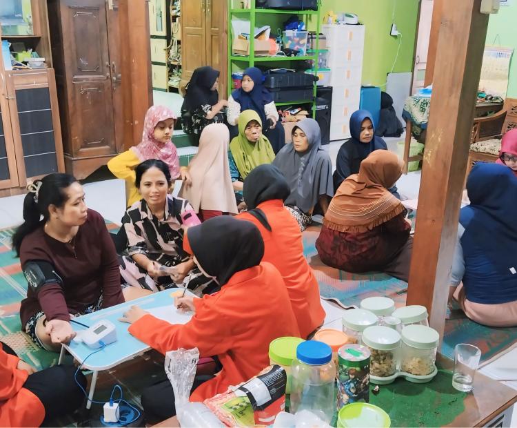 Mahasiswa KKN-IPE UM PKU Surakarta bersama ibu-ibu PKK Desa Tangkil dalam kegiatan cek kesehatan dan senam bersama.